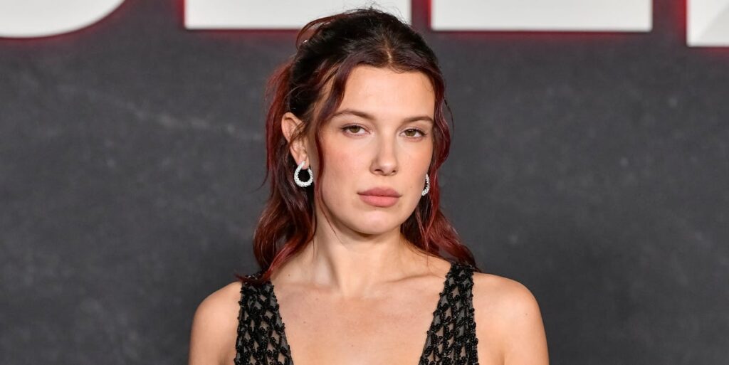 Millie Bobby Brown wears a see-through mesh dress with a plunging neckline